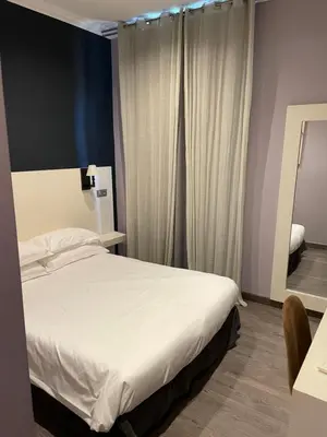 a bedroom with a white bed and a mirror at Chambre Le Chevalblanc