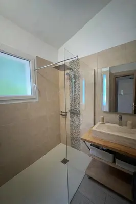 a bathroom with a shower and a sink at Mini-villa avec vue mer et piscine in Olmeto