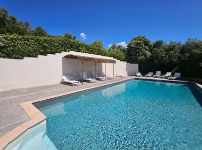 a swimming pool with chairs and a gazebo at Mini-villa avec vue mer et piscine in Olmeto