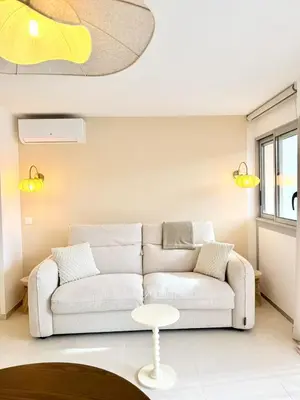 a living room with a white couch and a table at Studio neuf avec terrasse centre de Propriano in Propriano