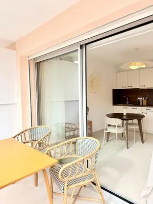 a room with a balcony with chairs and a table at Studio neuf avec terrasse centre de Propriano in Propriano
