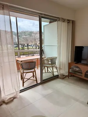 a living room with sliding glass doors and a balcony at Studio neuf avec terrasse centre de Propriano in Propriano