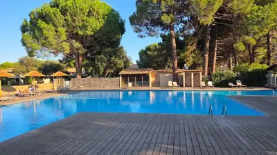 a large swimming pool with trees in the background at U Fiori Studio 37 in Lecci