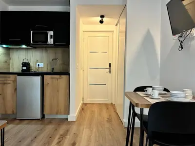 a kitchen with a table and a white door at U Fiori Studio 37 in Lecci