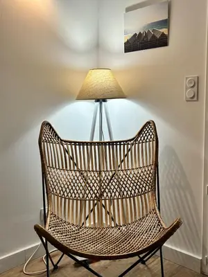 a wicker chair sitting next to a lamp at U Fiori Studio 37 in Lecci