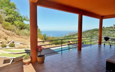 a house with a balcony with a view of the ocean at Villa Confina in Villanova