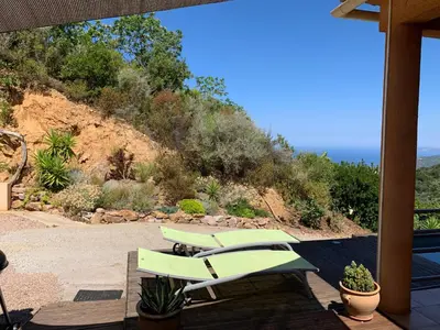 a patio with two green chairs and a view of the ocean at Villa Confina in Villanova