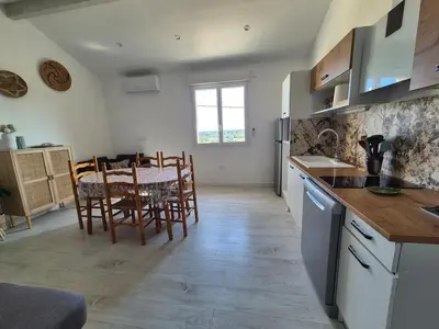 a kitchen and dining room with a table and chairs at Peaceful 3-room apartment, refurbished and air-conditioned in Linguizzetta