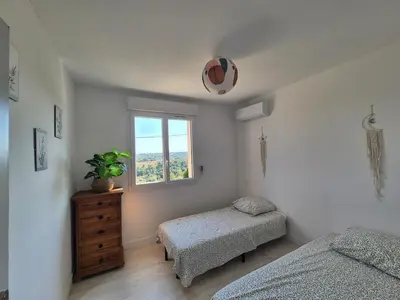 a bedroom with two twin beds and a window at Peaceful 3-room apartment, refurbished and air-conditioned in Linguizzetta
