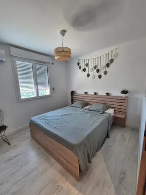 a bedroom with a bed with a wooden headboard and windows at Peaceful 3-room apartment, refurbished and air-conditioned in Linguizzetta