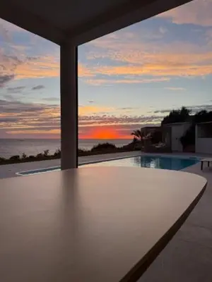 a view of the ocean from a house with a table at villa la baies des anges in Calcatoggio