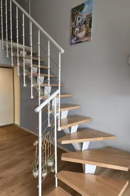 a spiral staircase in a home with wooden floors at Magnifique duplex vue mer avec clim wifi piscine mer à pied in Serra-di-Ferro