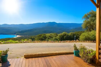 a porch with a view of a lake and mountains at Magnifique duplex vue mer avec clim wifi piscine mer à pied in Serra-di-Ferro