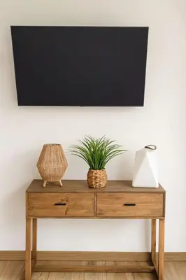 a tv on top of a wooden dresser with a plant on it at Magnifique duplex vue mer avec clim wifi piscine mer à pied in Serra-di-Ferro