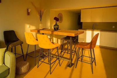 a kitchen with a table and stools in a kitchen at Magnifique duplex vue mer avec clim wifi piscine mer à pied in Serra-di-Ferro