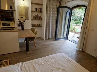 a kitchen and dining room with a table and a door at Le vieux moulin in Porto-Vecchio