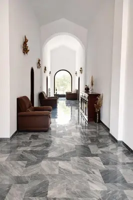 a living room with a tile floor and couches at Chambres de charme - 2 chambres indépendantes avec salles de bains privatives in Corte