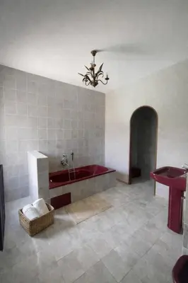 a large bathroom with a red tub and a table at Chambres de charmes - 3 chambres indépendantes avec salles de bains privatives in Corte