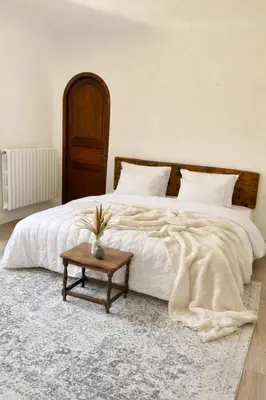 a bedroom with a large white bed with a table at Chambres de charmes - 3 chambres indépendantes avec salles de bains privatives in Corte