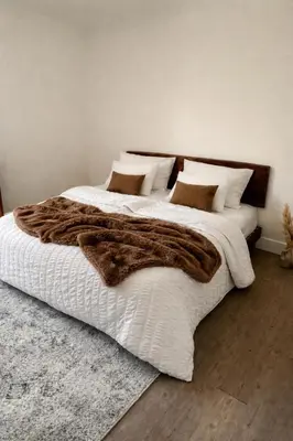 a bedroom with a large bed with a brown blanket at Chambres de charme - 4 chambres indépendantes et 3 salles de bains in Corte