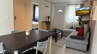a kitchen and living room with a table and a couch at Mini-villa Lisa 30 Résidence avec piscine Accès plage à pied in Sari Solenzara
