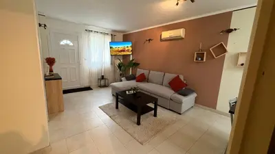 a living room with a couch and a table at Mini-villa Lisa 30 Résidence avec piscine Accès plage à pied in Sari Solenzara