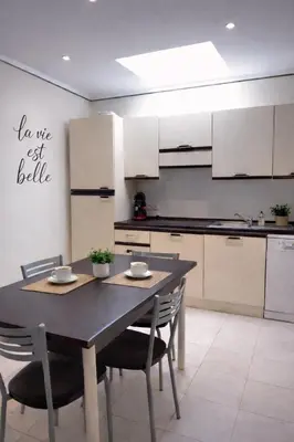a kitchen with a table and chairs in a room at Mini-villa Lisa 30 Résidence avec piscine Accès plage à pied in Sari Solenzara