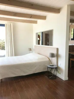 a bedroom with a bed and a large mirror at Villa On One Hectare Facing The Gulf Of Ajaccio in Coti-Chiavari