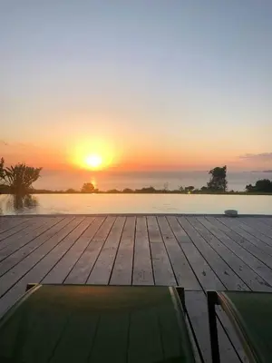 a wooden dock with the sunset in the background at Villa On One Hectare Facing The Gulf Of Ajaccio in Coti-Chiavari