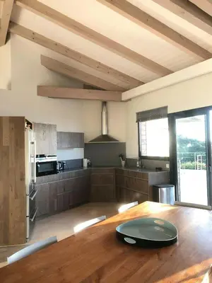 a kitchen with a wooden table with a plate on it at Villa On One Hectare Facing The Gulf Of Ajaccio in Coti-Chiavari