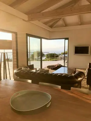 a living room with a leather couch and a table at Villa On One Hectare Facing The Gulf Of Ajaccio in Coti-Chiavari