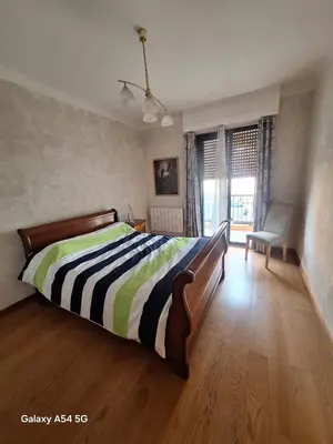 a bedroom with a bed with a striped comforter at Appartement confortable à Propriano avec balcon in Propriano