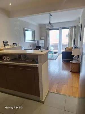 a kitchen with a counter and a living room at Appartement confortable à Propriano avec balcon in Propriano