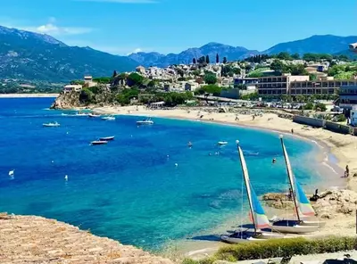 a beach with two sail boats in the water at Appartement confortable à Propriano avec balcon in Propriano