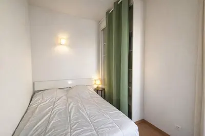 a bedroom with a bed and a green curtain at Studio centre-ville rue fesch Ajaccio in Ajaccio