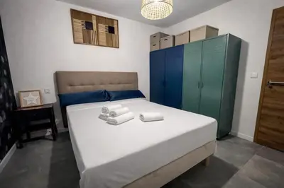 a bedroom with a bed with blue and green cabinets at Résidence Porticcio Vacations Vue Mer Piscine & Jacuzzi in Grosseto-Prugna