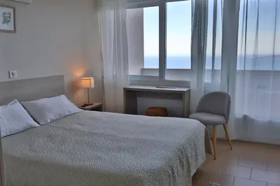 a bedroom with a bed and a desk and a window at le Belvedere in Coti-Chiavari