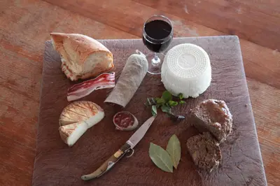a wooden cutting board with bread and a glass of wine at le Belvedere in Coti-Chiavari