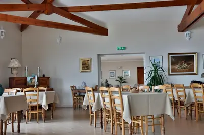 a dining room with tables and chairs and wooden ceilings at le Belvedere in Coti-Chiavari