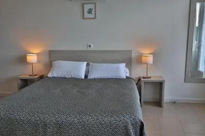 a bedroom with a bed with two lamps on two tables at le Belvedere in Coti-Chiavari
