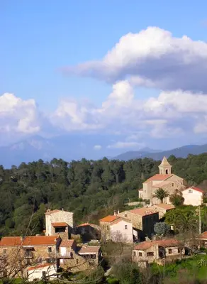 a group of houses on a hill with mountains in the background at le Belvedere in Coti-Chiavari