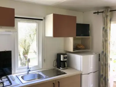 a small kitchen with a sink and a refrigerator at Mobil-home confortable avec terrasse pour 4 personnes à Vico - API-1-52-838 in Vico