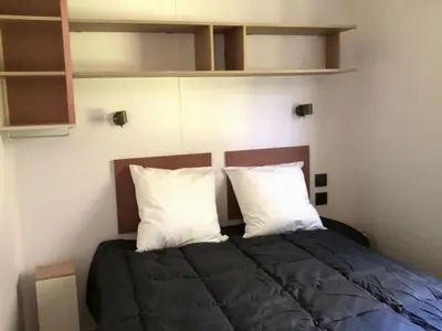 a bedroom with a bed with two white pillows at Mobil-home confortable avec terrasse pour 4 personnes à Vico - API-1-52-838 in Vico
