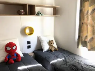 two stuffed animals sitting on a bed in a room at Mobil-home confortable avec terrasse pour 4 personnes à Vico - API-1-52-838 in Vico