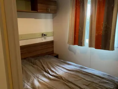 a small bedroom with a bed and a window at Mobil Home avec Terrasse, 2 Chambres, 4 Pers. - API-1-52-840 in Vico