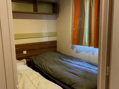 a small bedroom with a bed and a window at Mobil Home avec Terrasse, 2 Chambres, 4 Pers. - API-1-52-840 in Vico