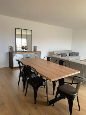 a wooden table and chairs in a room with a bed at Superbe appartement Solenzara in Sari Solenzara