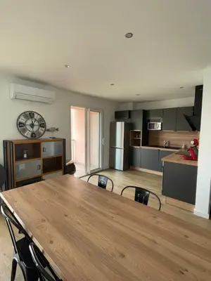 a large kitchen with a wooden table and chairs at Superbe appartement Solenzara in Sari Solenzara