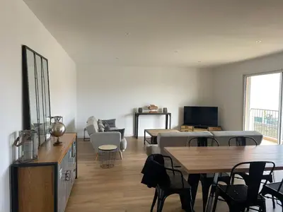 a living room with a table and a couch at Superbe appartement Solenzara in Sari Solenzara