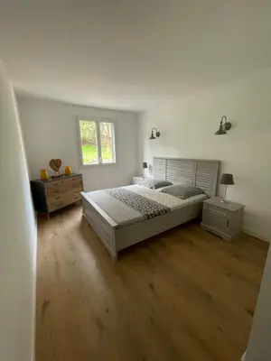 a bedroom with a large bed and a wooden floor at Superbe appartement Solenzara in Sari Solenzara